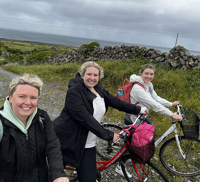 3 happy female beer trippers walking bikes on the coast of ireland