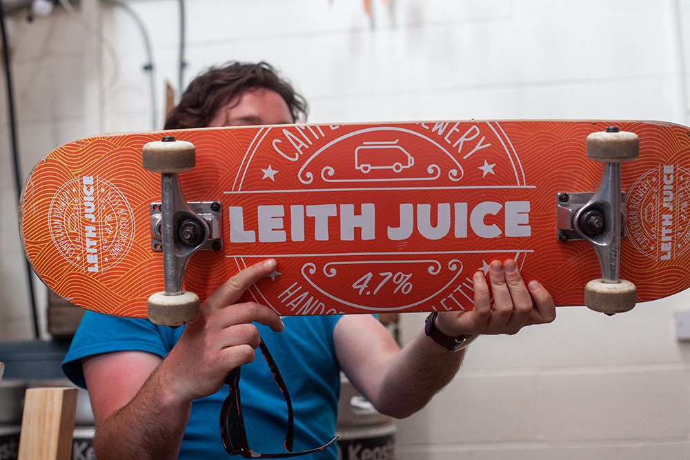 Brewer at Campervan Brewery Holding Leith Juice Skateboard