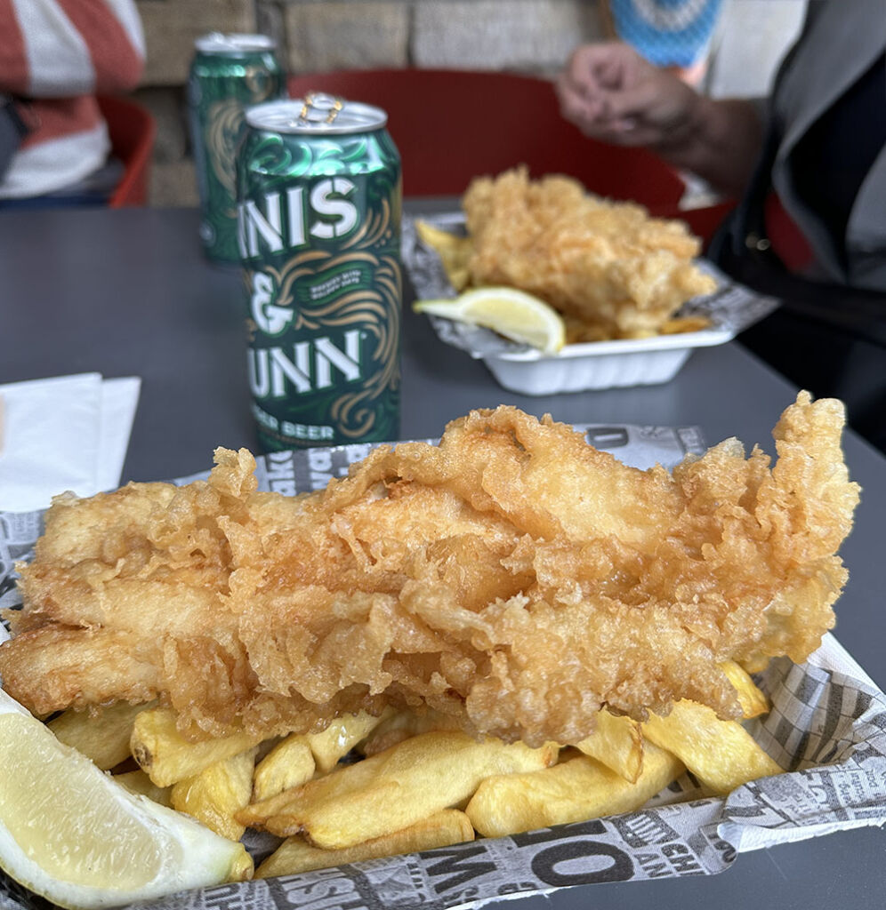 authentic fish and chips with beer can in background